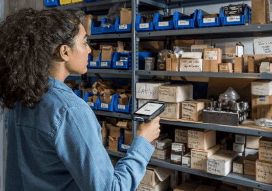 A girl is using a handheld rfid reader to check or track items stored on shelves.